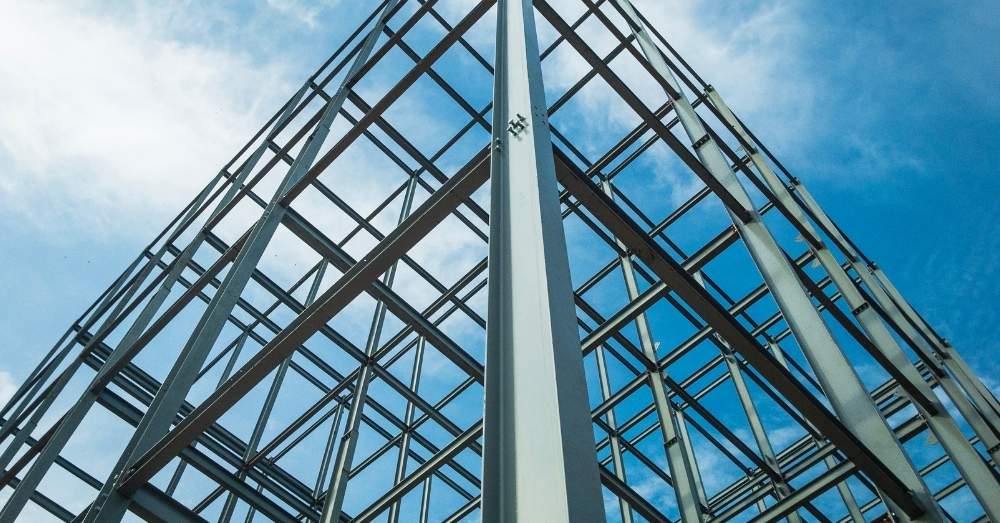 A hand pours a beer from a row of taps at a bar