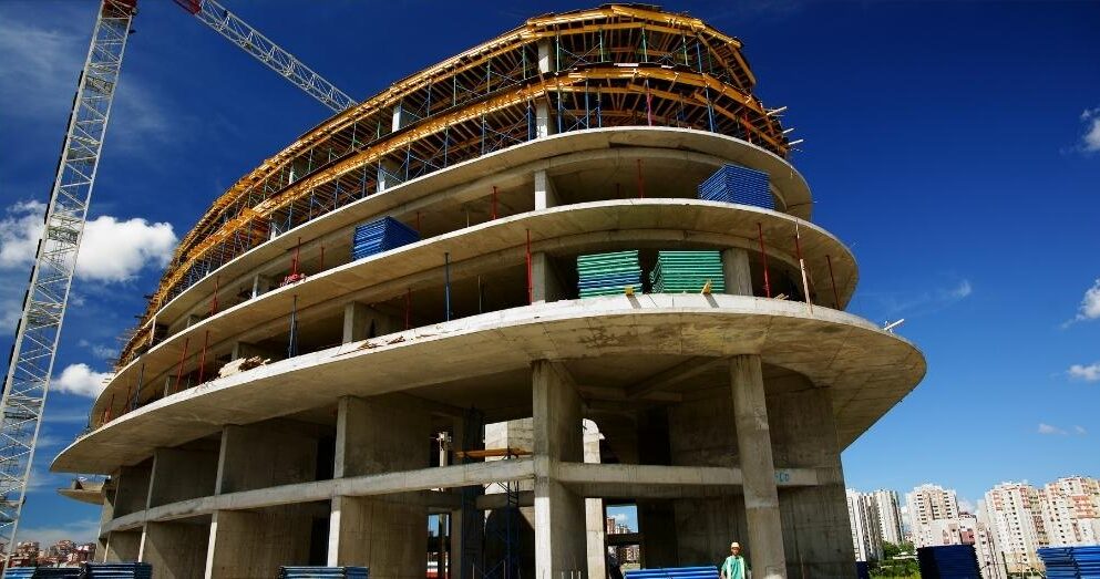 A multi-story curved building under construction.