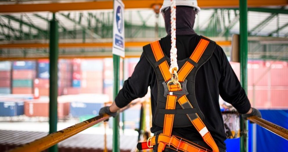 A construction worker wears a safety harness.