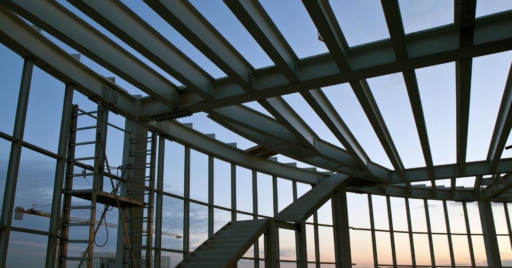 The exposed steel skeleton of a building against the sky.