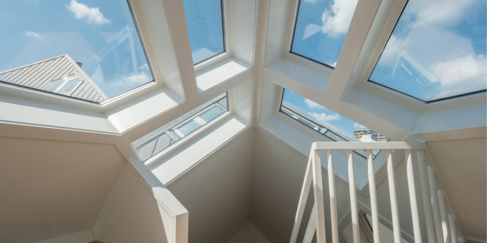 Custom architectural skylight installation above a staircase with expansive glass panels and natural daylight