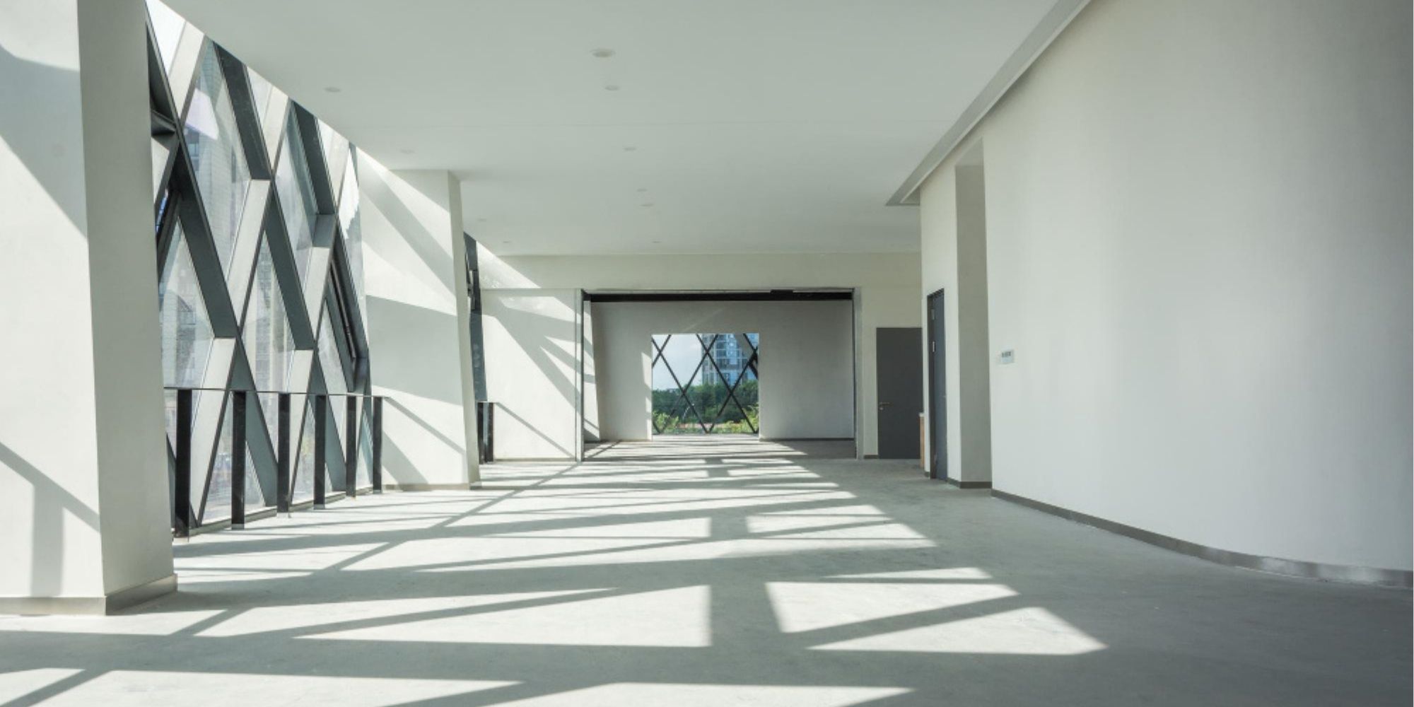 Open commercial building interior featuring large architectural windows and bright natural lighting